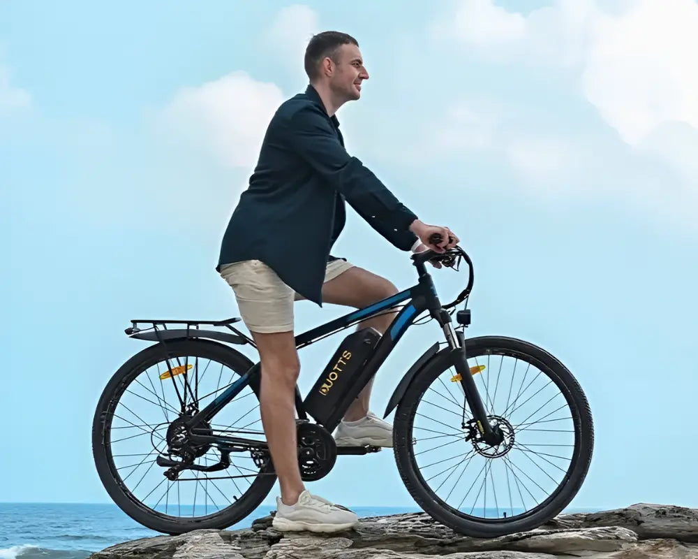 man riding DUOTTS C29 PRO Electric Bike on a rocky beach