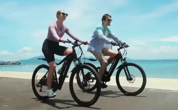 Young couple riding WELKIN electric bikes on seaside